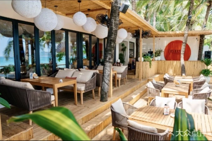 Freegen’s shaded wooden terrace with cushioned seating and round pendant lights