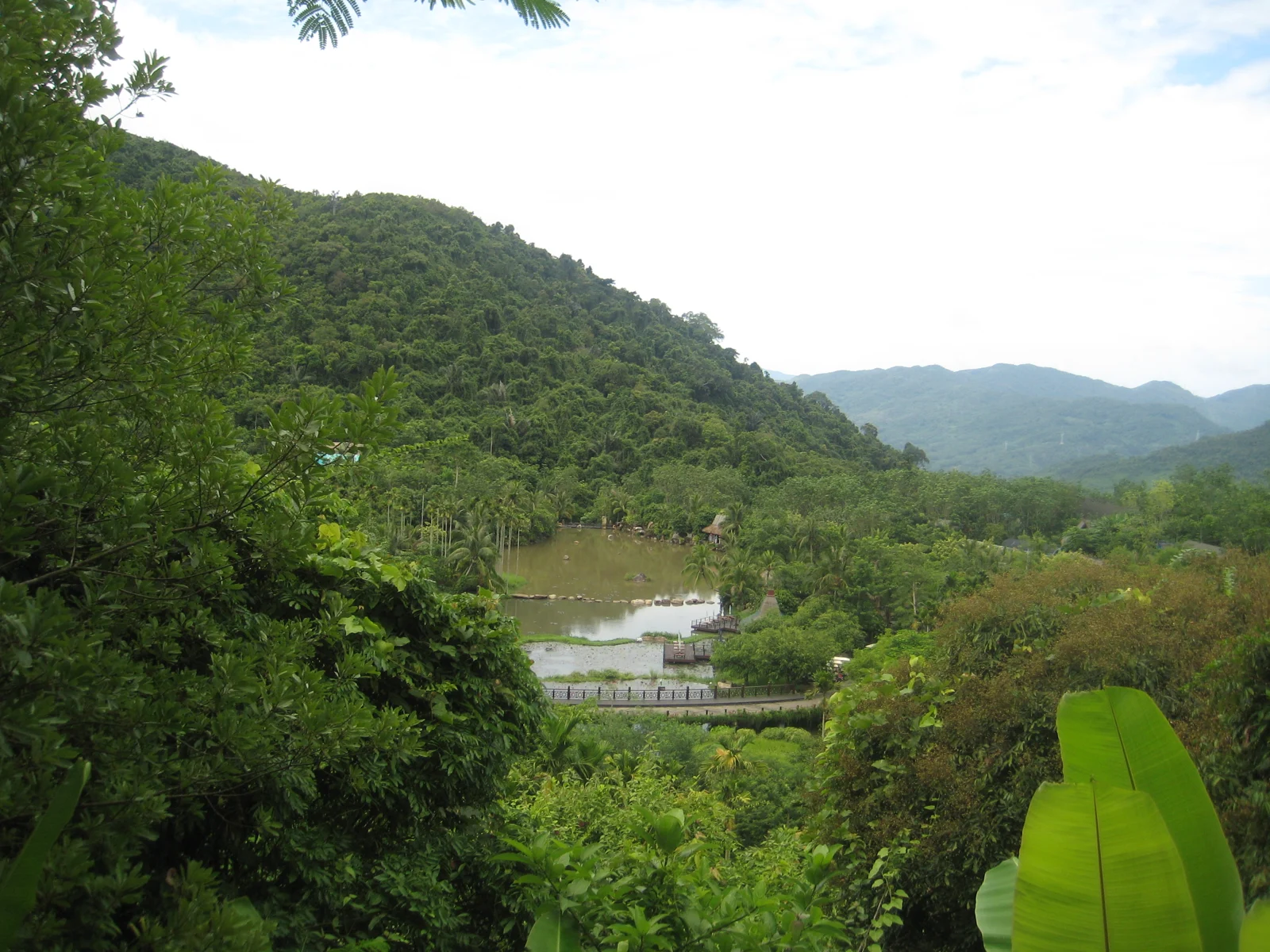 Forested hills surrounding a pond and paths in Yanoda rainforest park