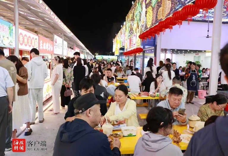 Crowds dining and browsing food stalls beneath red lanterns at Yiheng Night Market in Sanya