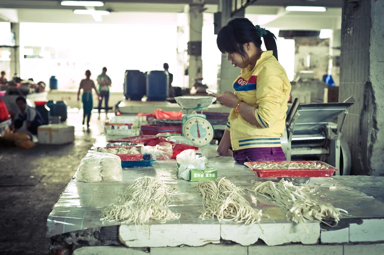 A noodle seller inside a central market in Sanya