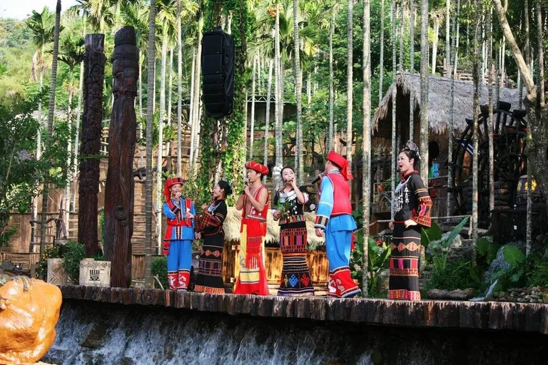 Performers in colourful costumes on a stage at Binglanggu