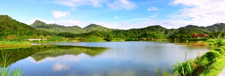 Green mountain ridges reflected in Tianchi lake at Jianfengling