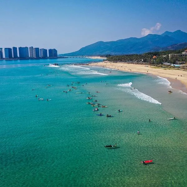 Surfers waiting for waves in turquoise water at Riyue Bay