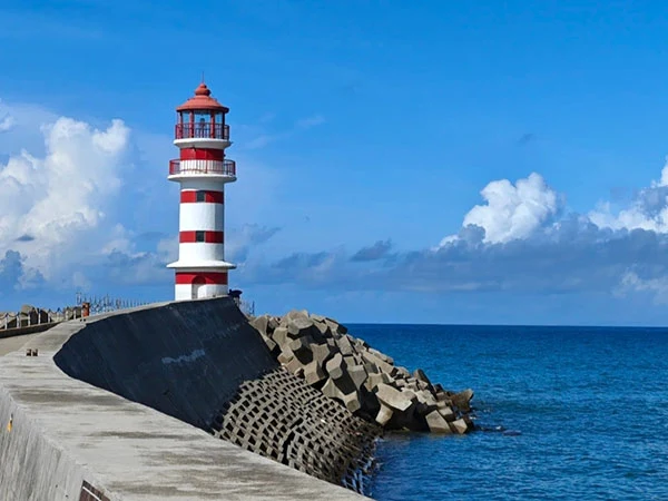 Red-and-white lighthouse and blue sea at Shenzhou Peninsula